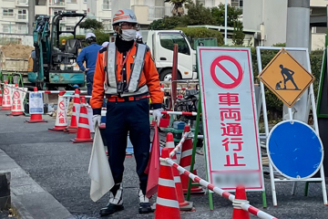 西宮市内のガス管取替工事現場で交通誘導する警備員スタッフ