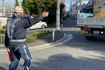 豊中市の敷地内管路新設現場で交通誘導警備をする警備員