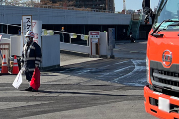 鶴見区の駐車場舗装工事現場で交通誘導警備をする警備員