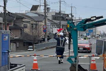 京都市の橋梁下ガス管取替工事現場で交通誘導警備をする警備員