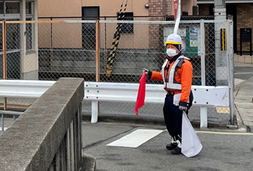 京都市内の橋梁下ガス管取替工事現場で交通誘導中をする警備員3