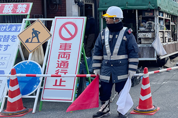 堺市内のガス管取替工事現場で交通誘導をする風景