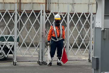 東淀川区の工事ヤード内施工現場で交通誘導警備中の警備員3